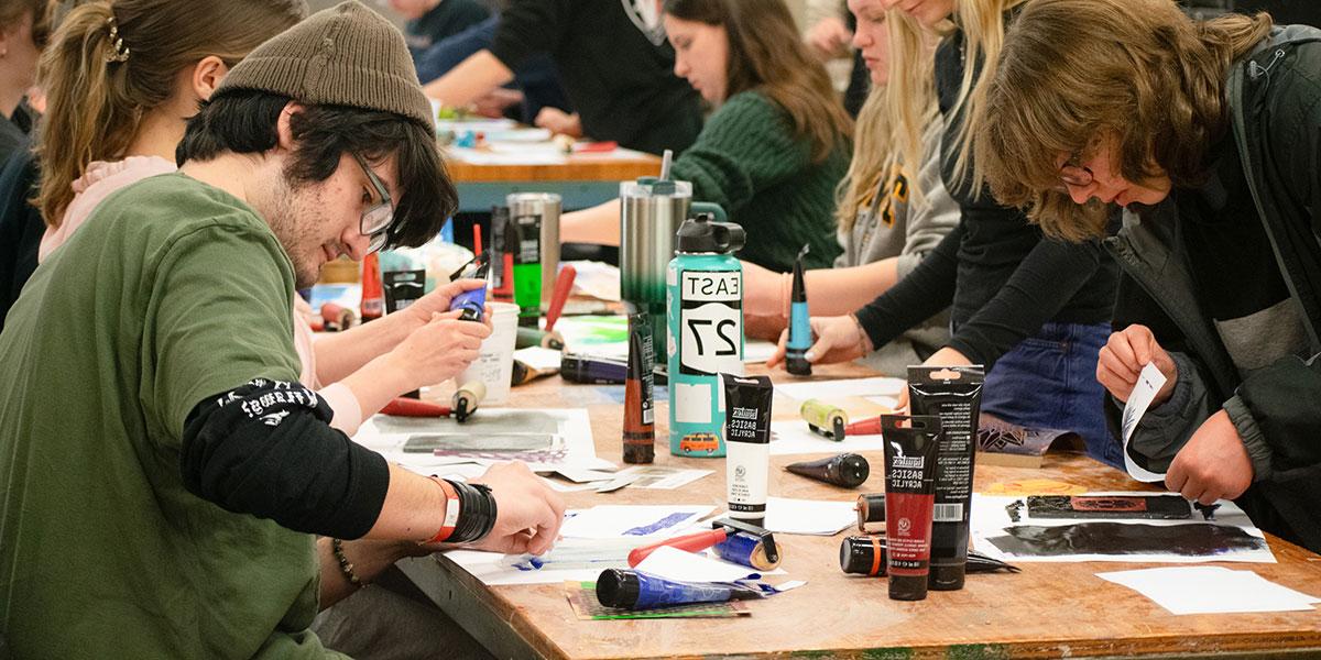 Students sitting at a table working on an art project